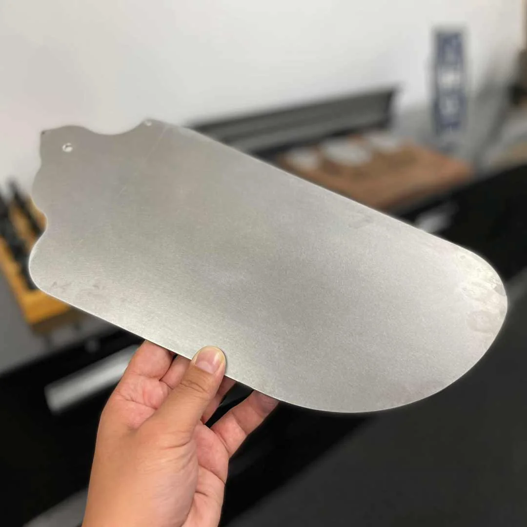 Waterjet cut part held by a team member at Genoa Tool.